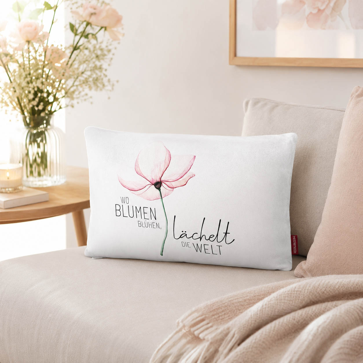 Kissen mit Spruch Wo Blumen blühen, lächelt die Welt mit rosa Blüte und rosa Rückseite vor Mohnblumen