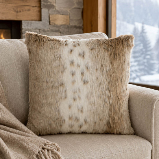 Langhaar-Kuschelkissen in Braun und Cremeweiß auf einem Sofa