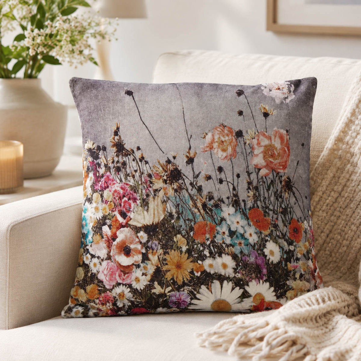 Dekokissen „Lundby“ in Grau mit Blumenwiese auf einem Sofa dekoriert