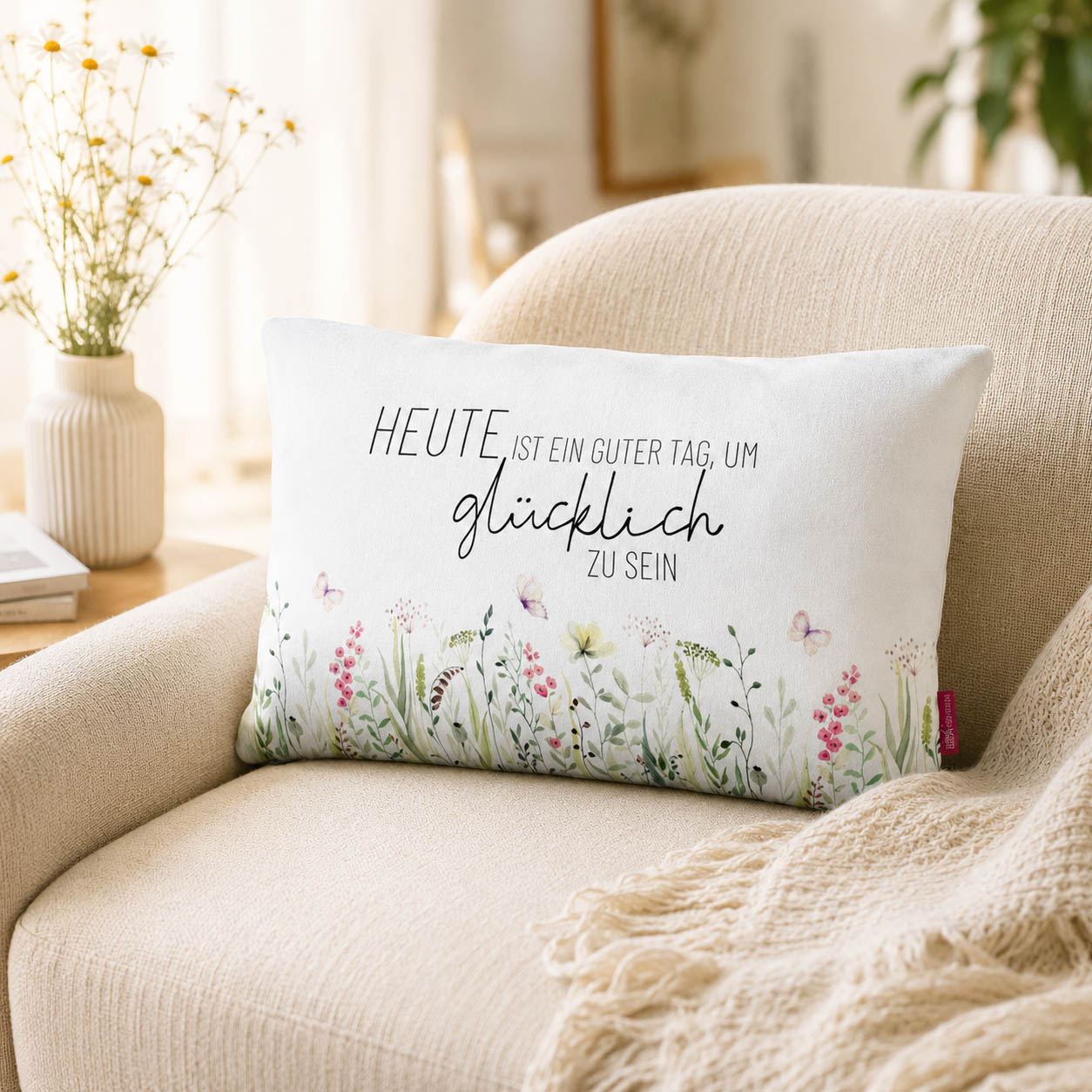 Kissen mit Spruch Heute ist ein guter Tag, um glücklich zu sein mit Blumenwiese und grüner Rückseite in sommerlicher Wiesenszene