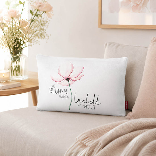 Kissen mit Spruch Wo Blumen blühen, lächelt die Welt mit rosa Blüte und rosa Rückseite vor Mohnblumen