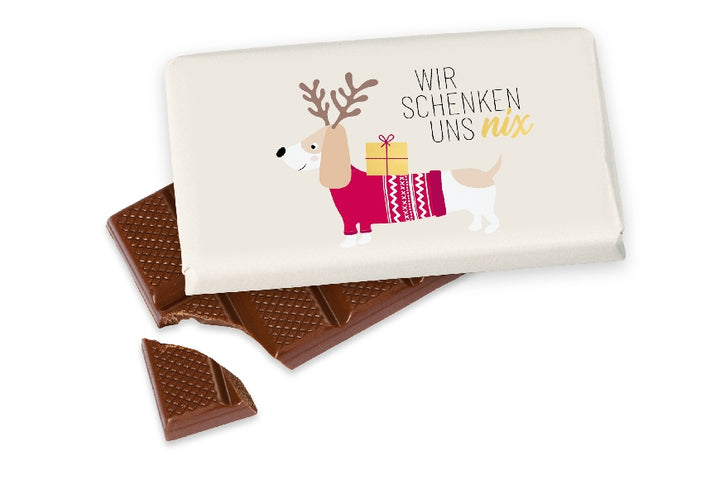 Kleine Vollmilchschokolade (40 g) mit Weihnachts-Dackel-Motiv & Aufschrift „Wir schenken uns nix“ von Geschenk für Dich