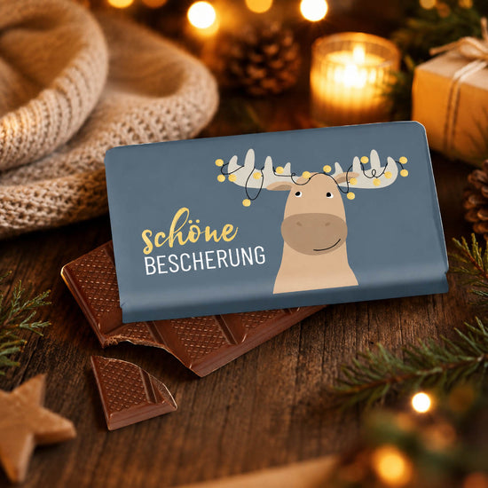 Schokolade „Schöne Bescherung“ – Stimmungsbild mit Elch-Tafel im weihnachtlichen Ambiente