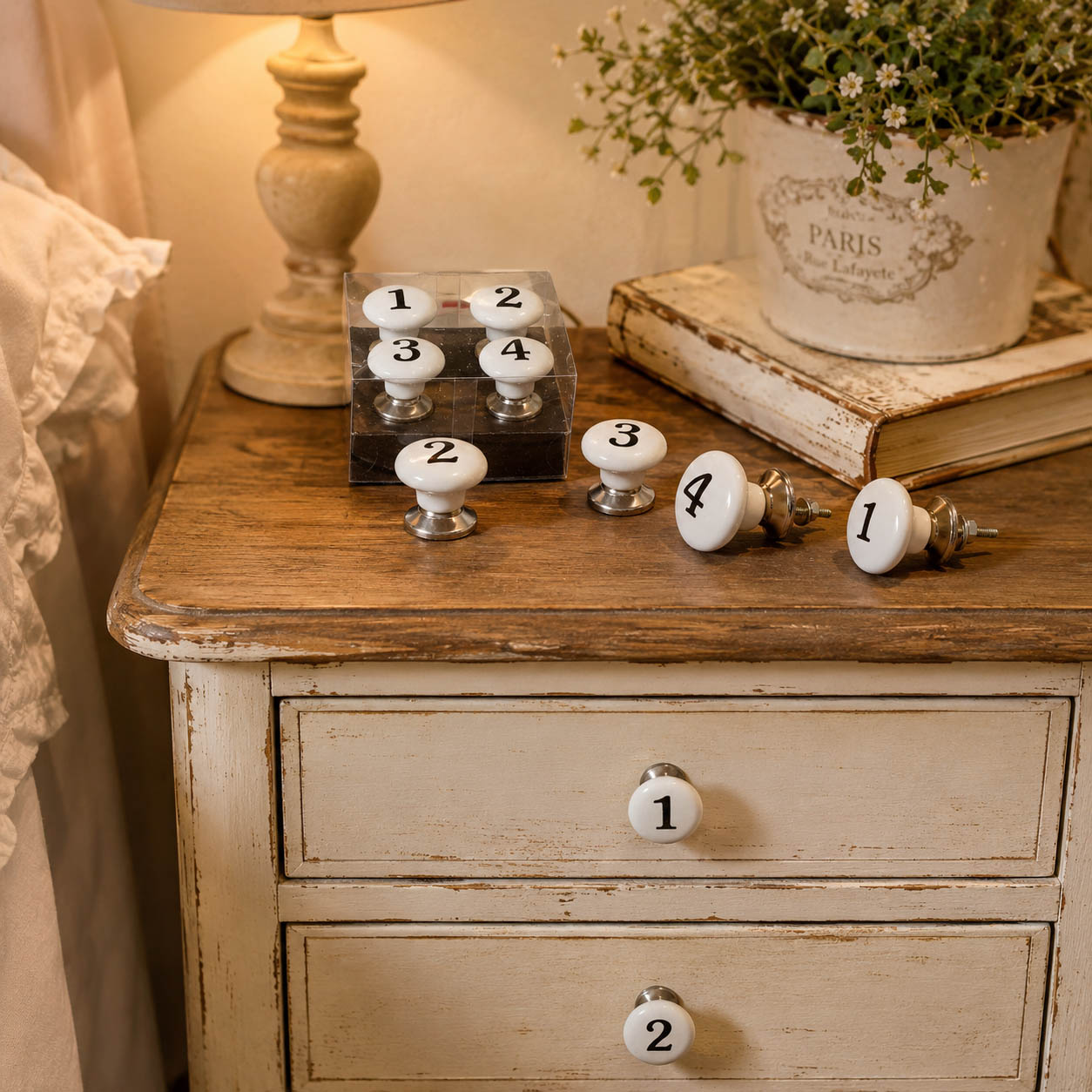 Nummerierte Möbelknöpfe aus Keramik auf einem Shabby Chic Nachttisch im Landhausstil