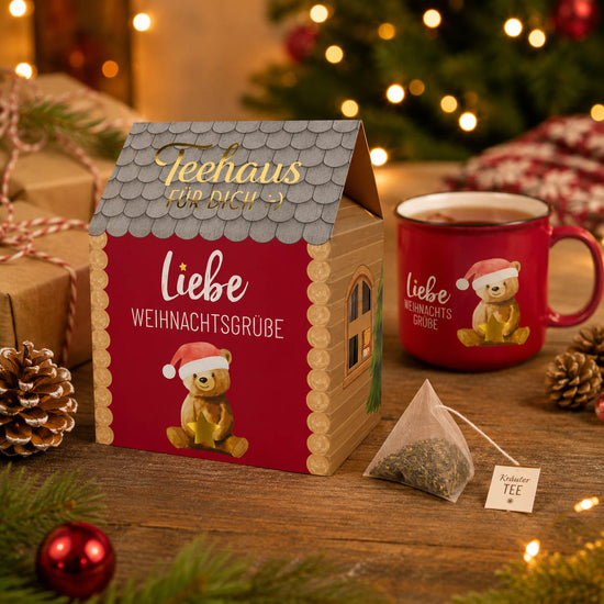 Teehaus Liebe Weihnachtsgrüße mit dampfender Tasse Tee und Teepyramide auf gemütlichem Weihnachtstisch