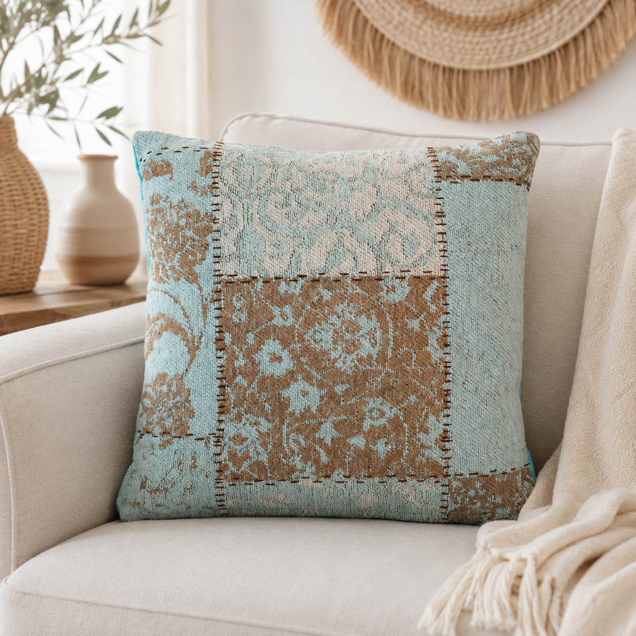 Türkis-petrolfarbenes Patchwork-Kissen auf einem Sofa als farbiger Akzent