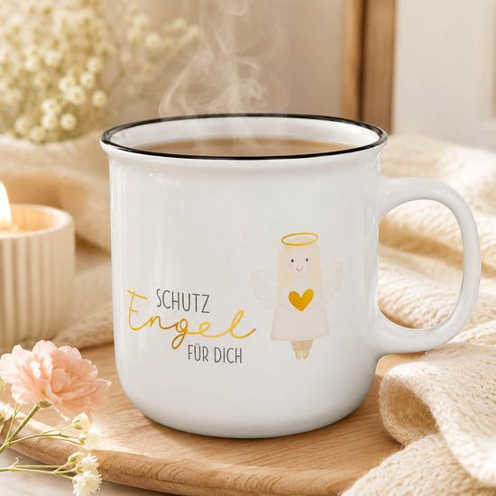 Kultbecher „Schutzengel für Dich“ in Weiß mit Engel-Motiv, stimmungsvoll auf Holzbrett mit Kerze, Nelke und Strickdecke – Geschenk für Dich
