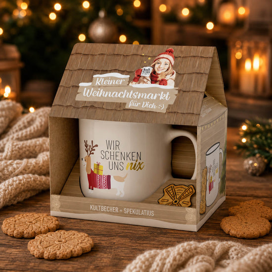 Cremeweißer Kultbecher Wir schenken uns nix mit Dackel-Motiv und Spekulatius auf weihnachtlichem Tisch